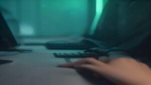 Pessoa jogando videogame no celular usando um controle físico conectado ao smartphone em um ambiente com luzes RGB.